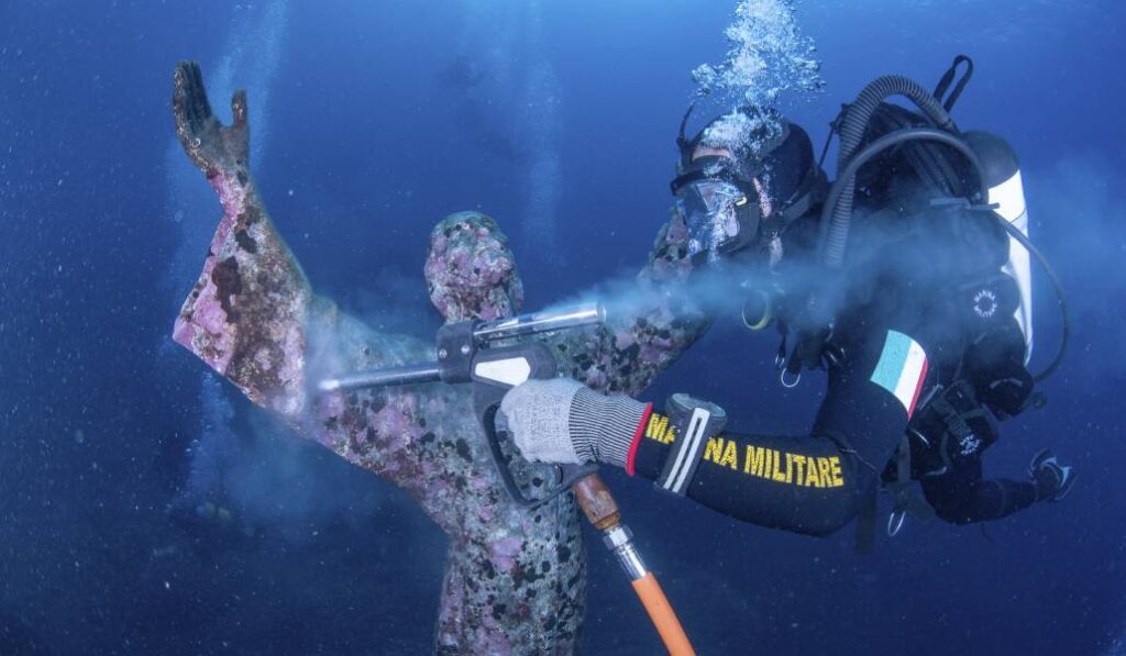Un buzo de la Marina italiana limpia la estatua de bronce.
