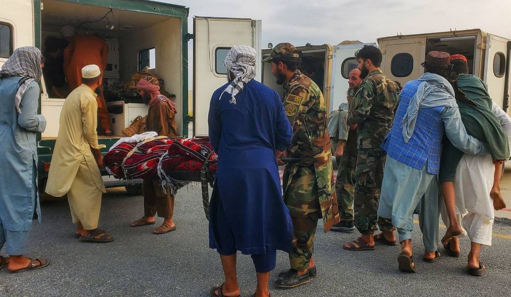 Soldados talibanes y civiles transportan a víctimas del terremoto a una ambulancia en un aeropuerto en Jalalabad, Afganistán