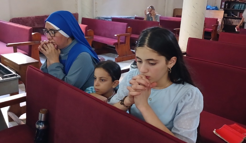 Algunas de las protagonistas del vídeo rezan con una religiosa