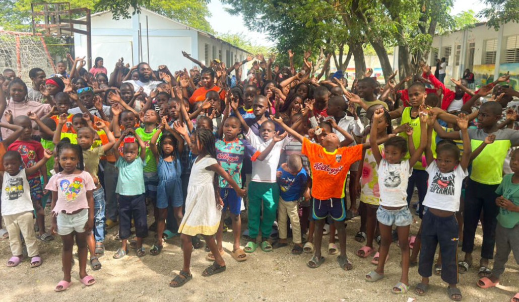 Los niños posan con los brazos levantados durante la mudanza.