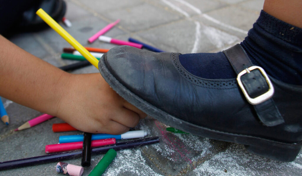 Foto de recurso de un pie pisando una mano