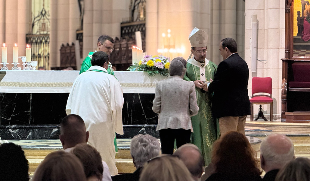 El arzobispo recibe el pan y el vino de manos de un matrimonio, padres de un sacerdote.