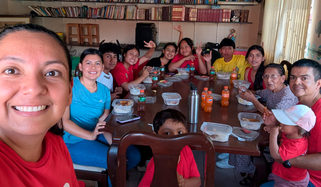 Luz (izquierda) y Javier (primero por la derecha) comparten el momento de la comida con algunos de los alumnos