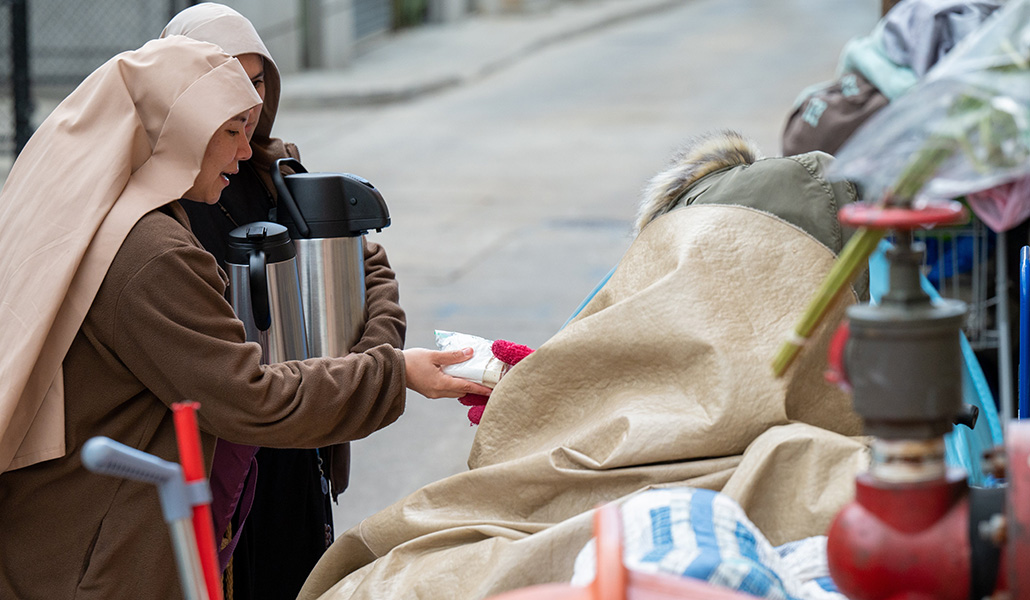 Las Hermanas Pobres de Jesucristo distribuyen alimentos y conversan con personas sin hogar en las calles del centro de Baltimore el 3 de mayo de 2023
