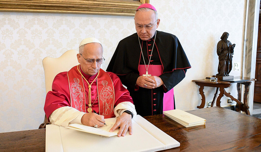 El Santo Padre firma la exhortación en presencia de Edgar Peña, número tres de la Secretaría de Estado.