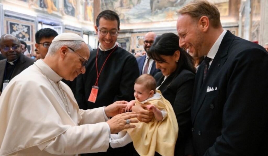 León XIV saluda a una familia durante la audiencia.
