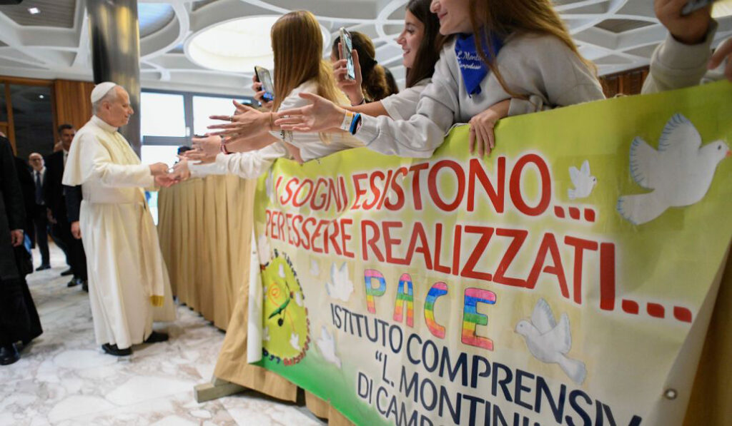 León XIV acompaña a unos jóvenes con pancartas en el Jubileo del Mundo de la Educación.