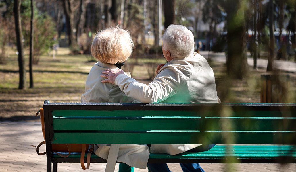 Foto de recurso de una pareja de personas mayores sentadas en un banco en un parque