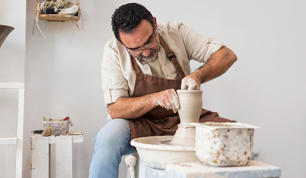 Foto de recurso de un hombre trabajando el barro con sus manos