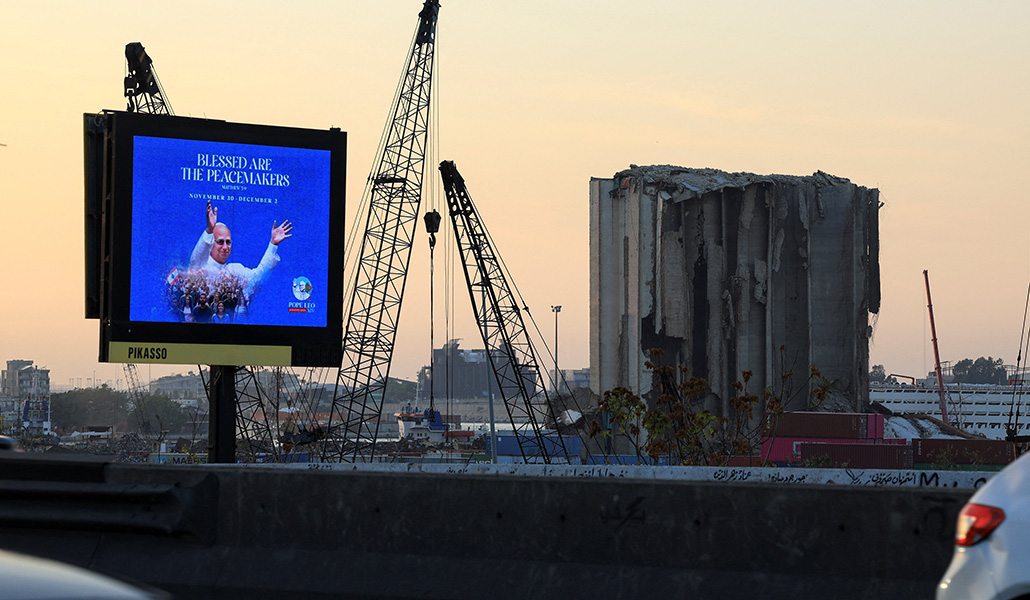 Cartel dando la bienvenida a León XIV en las proximidades del puerto de Beirut, aún dañado.