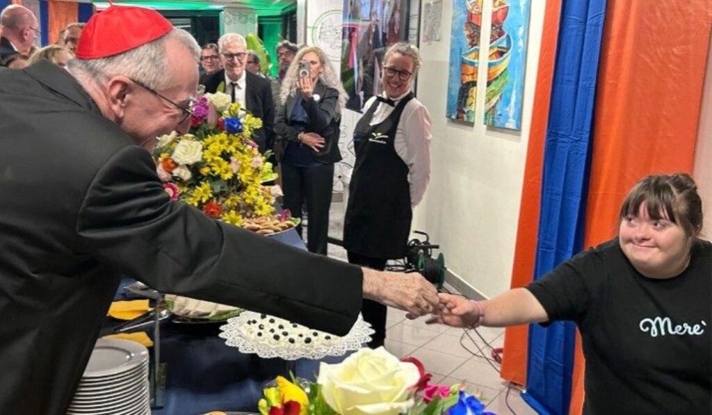 Pietro Parolin saluda a una usuaria en el centro.