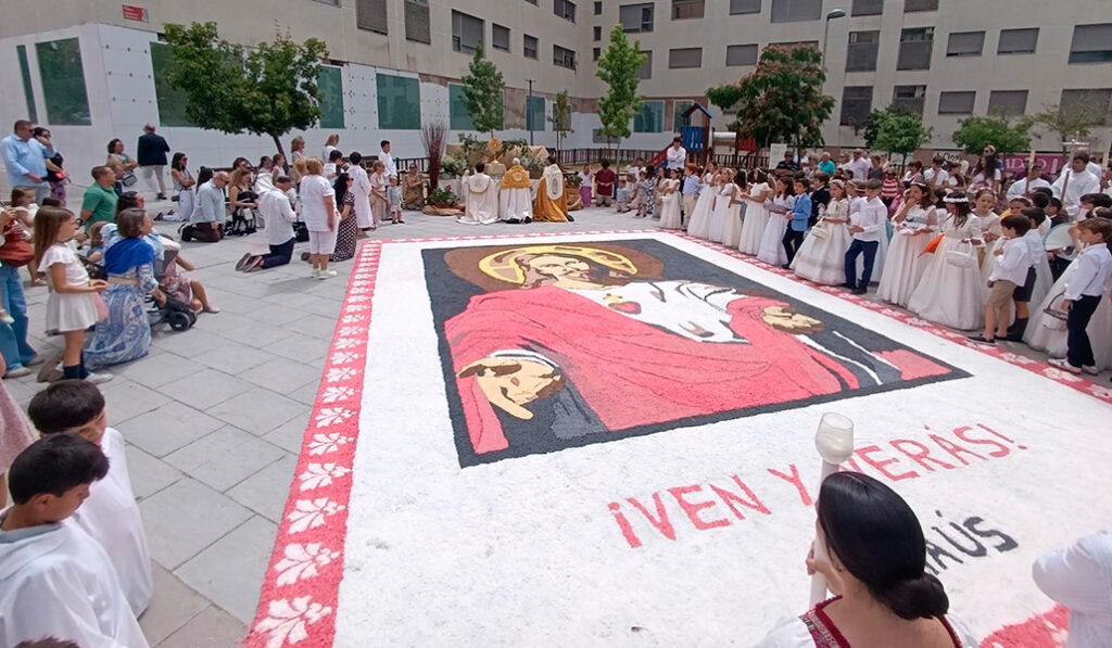 Las plazas del barrio se adornan con alfombras de flores en la fiesta del Corpus Christi.
