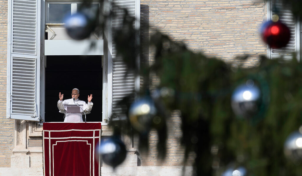 El Papa León XIV saluda a los visitantes que lo acompañan en el rezo del ángelus en la plaza de San Pedro del Vaticano el 21 de diciembre de 2025.