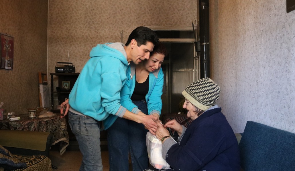Voluntarios llevan alimentos a una anciana. Foto: Maristas Azules.
