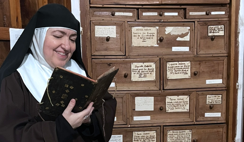 Manzano lee el recetario delante de un mueble de su archivo.