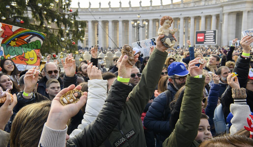 Los niños sujetan las figuras del Niño Jesús para que las bendiga el Papa. Foto: CNS photo / Vatican Media.