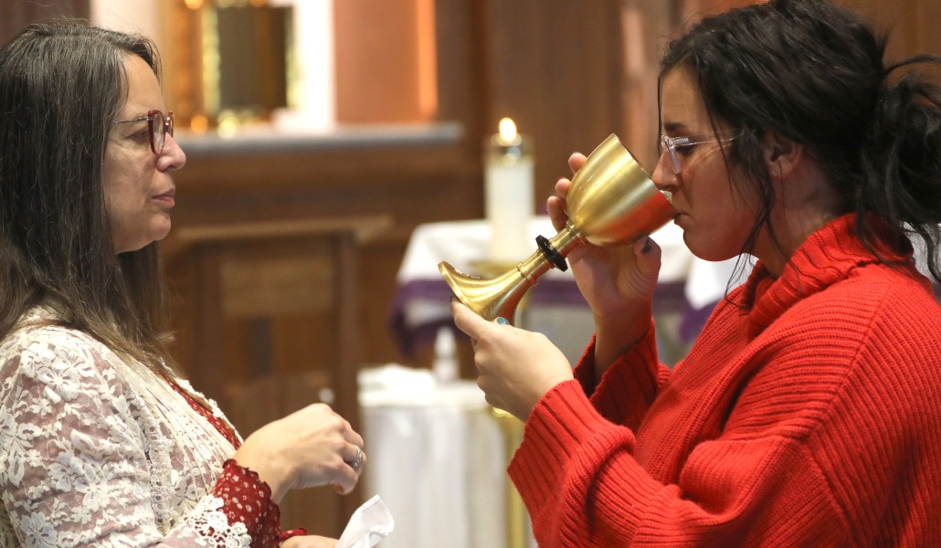 Una mujer, ministra de la Comunión, ofrece el cáliz a otra en una Misa en Arizona. La comisión Petrocchi pide promover los ministerios femeninos.