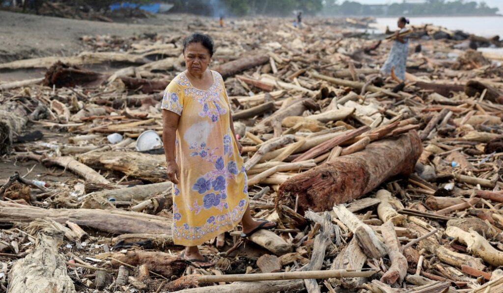 Una mujer entre los troncos arrancados por la riada en Padang (Sumatra, Indonesia). Foto: CNS / Reuters.