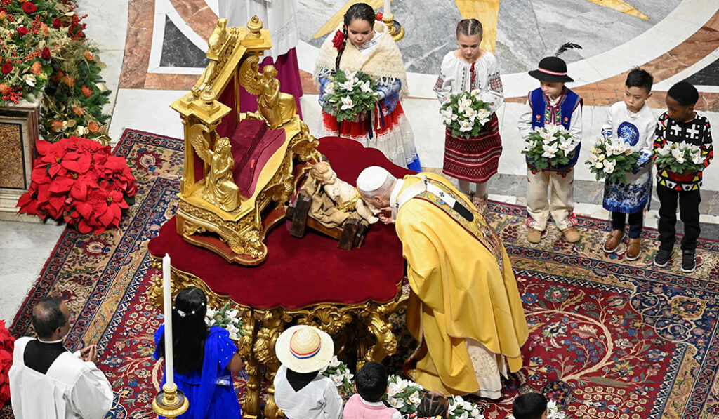 El Papa León XIV besa los pies de una estatua del Niño Jesús al comienzo de la Misa de Navidad en la basílica de San Pedro en el Vaticano, la noche del 24 de diciembre de 2025.
