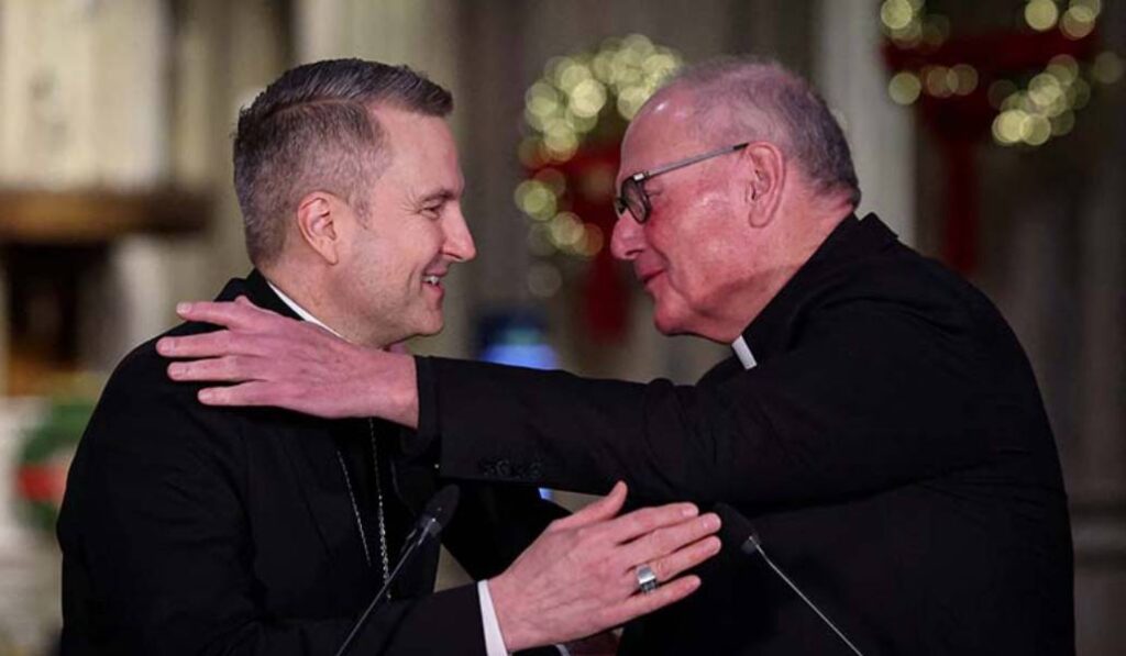Hicks, nuevo arzobispo de Nueva York, y Dolan se abrazan durante la rueda de prensa. Foto: CNS.