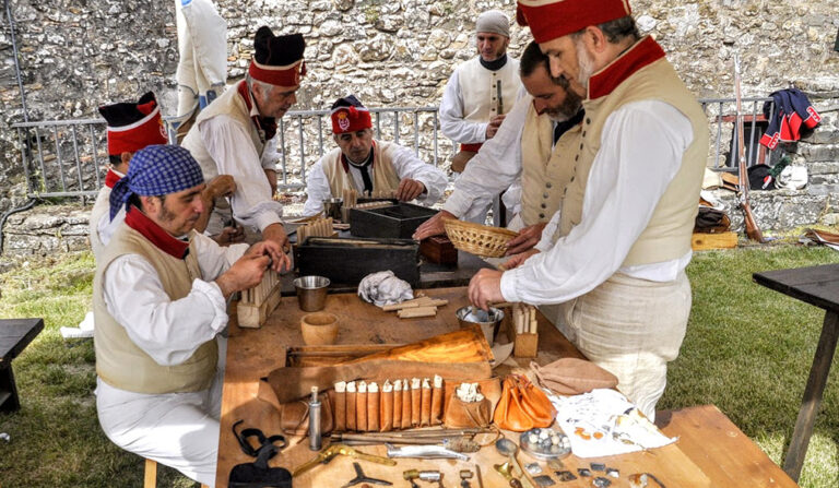 Miembros del grupo de recreación histórica, Voluntarios de Aragón, preparan cartuchos de pólvora para la batalla.
