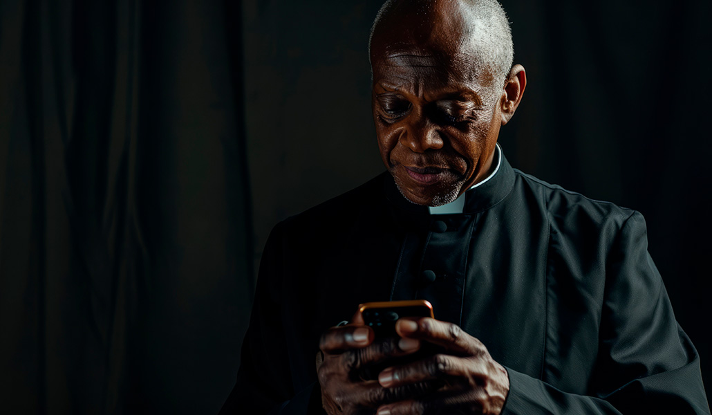 Foto de recurso de un sacerdote mirando el móvil