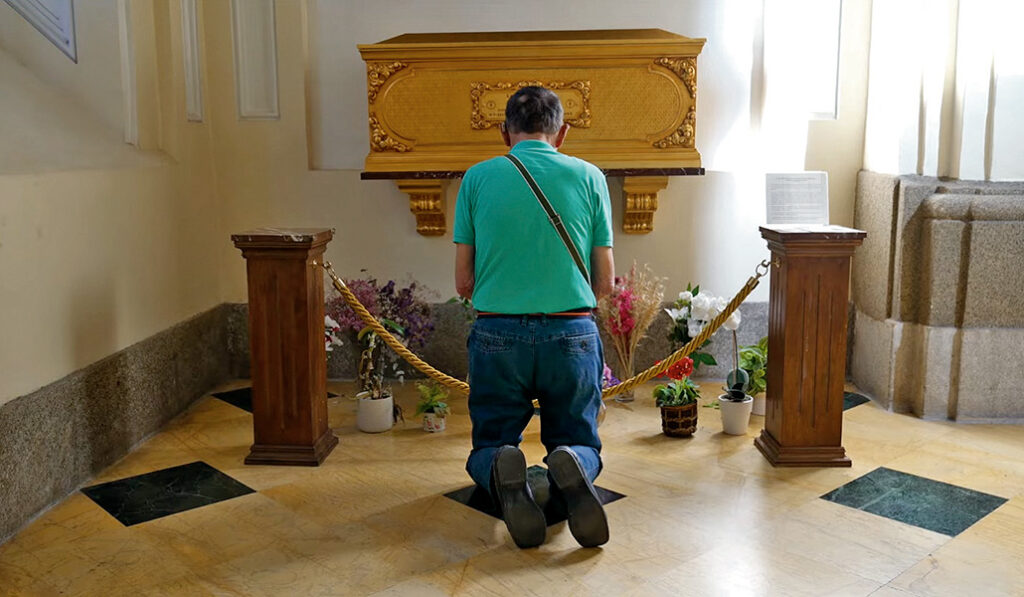 Un devoto reza ante la tumba de Alexia en San Martín de Tours, en Madrid.