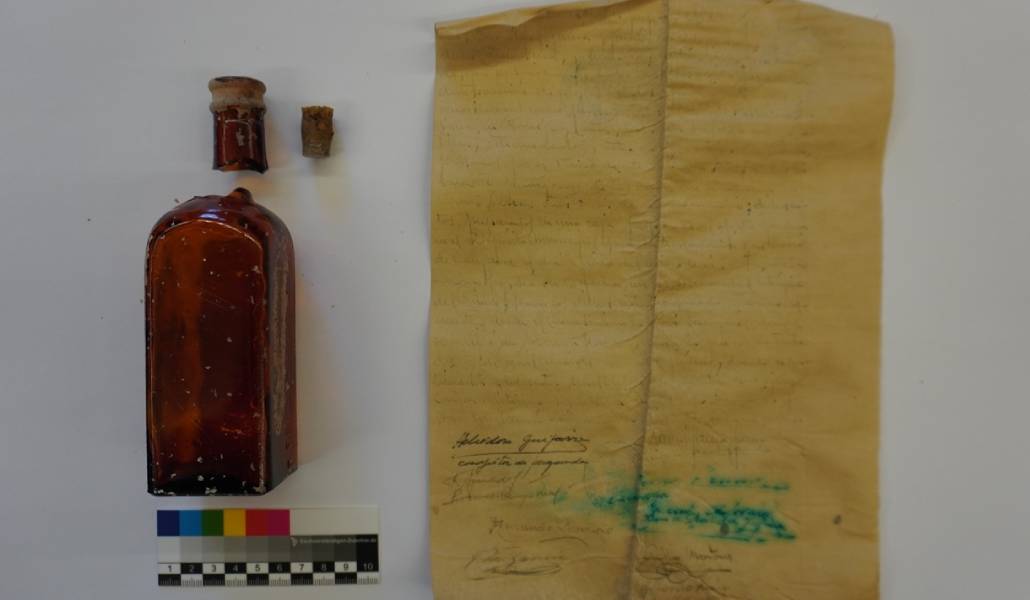 La botella y el documento hallados en Campo Real. Foto: Diócesis de Alcalá de Henares.