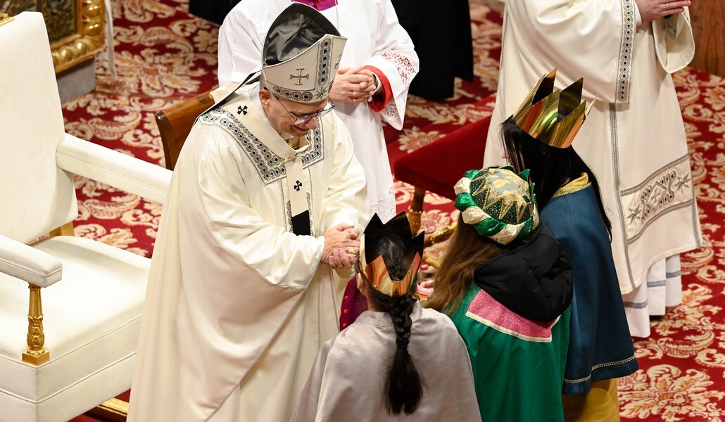El Papa recibe el ofertorio de manos de tres niños vestidos de Reyes Magos. Foto: CNS Photo / Vatican Media.