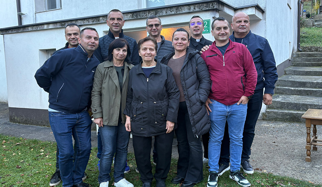 El sacerdote (detrás, cuarto) con su madre (centro) y hermanos.