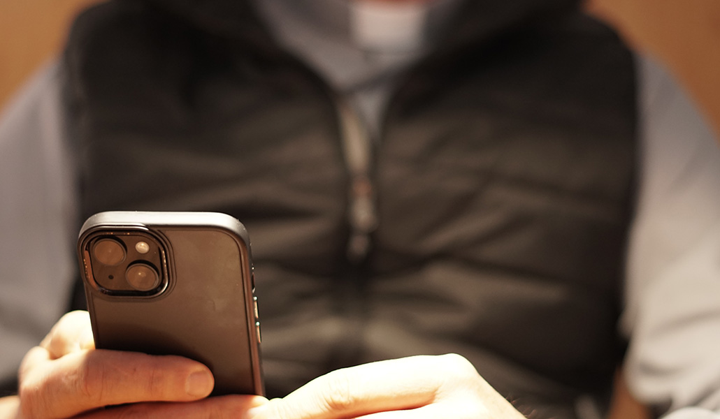 Foto de recurso de un sacerdote con un móvil en la mano