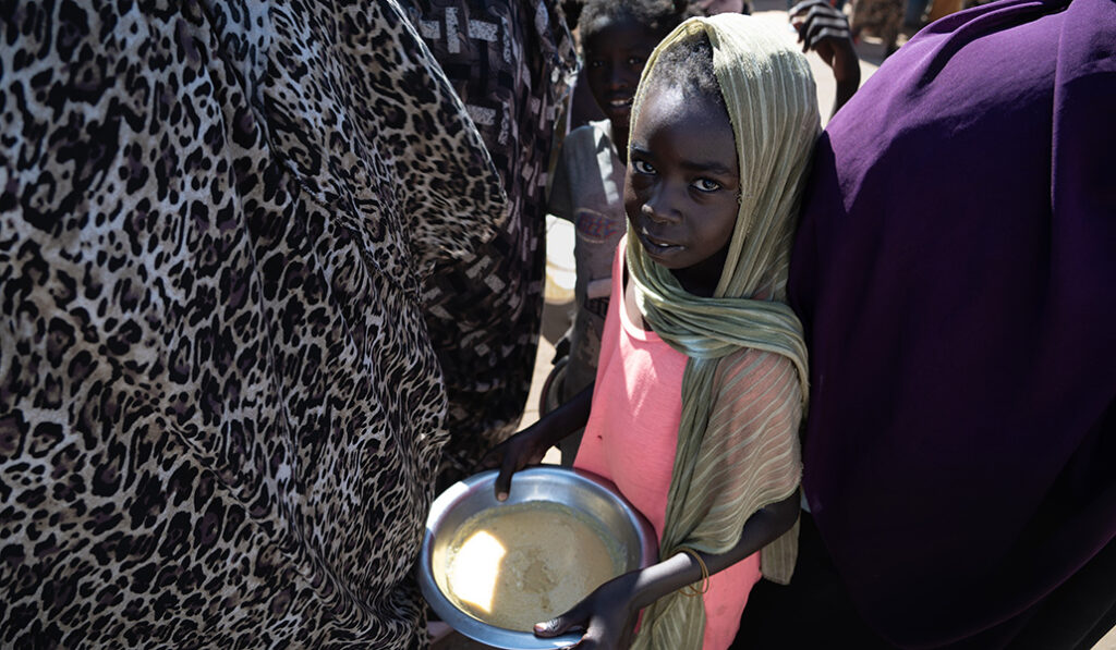 Una niña muestra su ración de lentejas. Es la comida que recibe dos veces al día.
