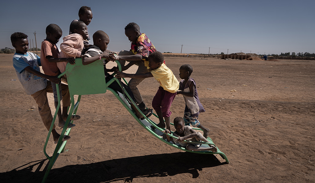 Los niños del campamento se divierten en un tobogán en medio del desierto.