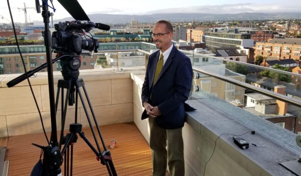 John Allen grabando una noticia desde una azotea.