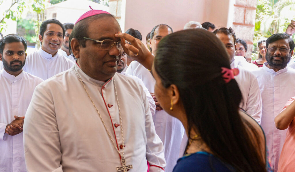 Una mujer hace un bindi en la frente de Poola como signo de respeto. Foto: AFP / Noah Seelam.