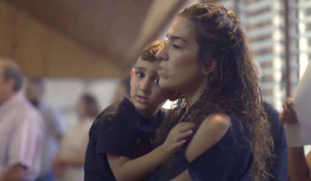 Una madre con su hijo en una celebración en Tierra Santa. Foto: YouTube Christian Media Center.