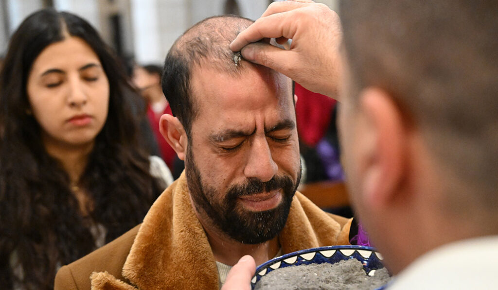 Un sacerdote coloca cenizas en la cabeza de un palestino durante la Misa del Miércoles de Ceniza en la Iglesia de Santa Catalina en Belén, Cisjordania, 5 de marzo de 2025.