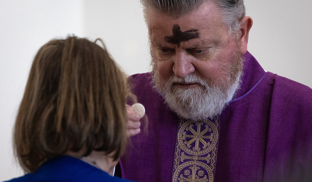 El padre Frank Watts, ministro sacramental del Hospital Ascension Sacred Heart Bay en la ciudad de Panamá, Florida, distribuye la Comunión durante la Misa del Miércoles de Ceniza el 5 de marzo de 2025.