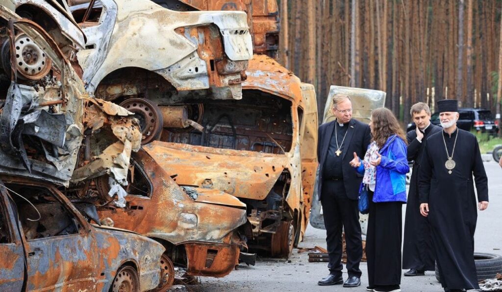 La presidenta de Cáritas Ucrania visita vehículos destrozados con dos obispos. Foto: Cáritas.