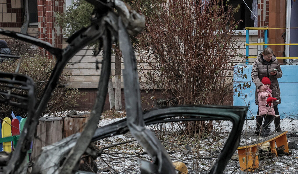 Una mujer y un niño se encuentran en el lugar de una guardería dañada tras un ataque con misiles en Kiev (Kiev), Ucrania, el 13 de diciembre de 2023, en medio de la invasión rusa.