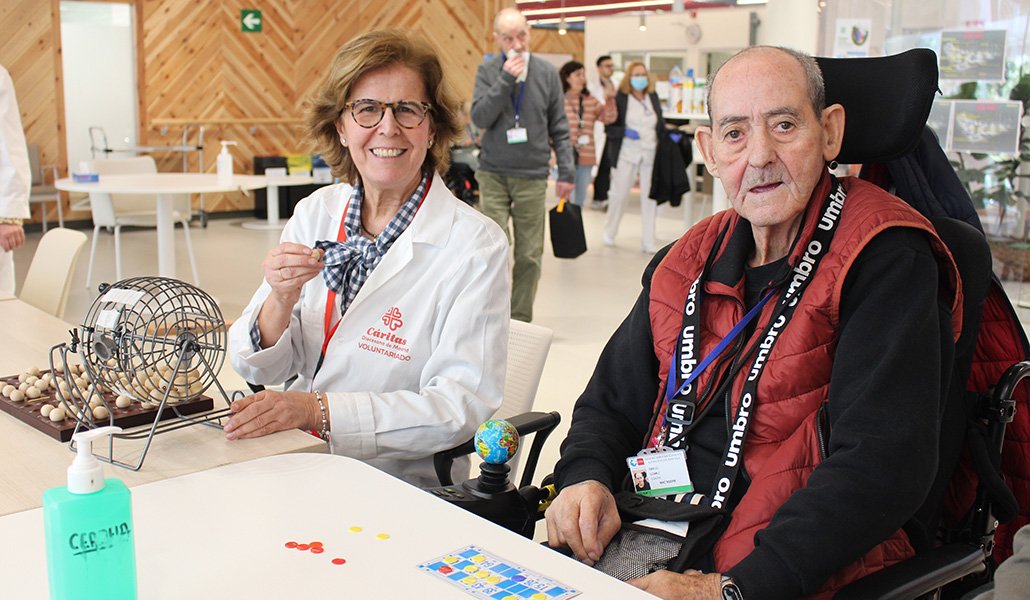 Carmen Gracia canta el bingo junto a un paciente de ELA.