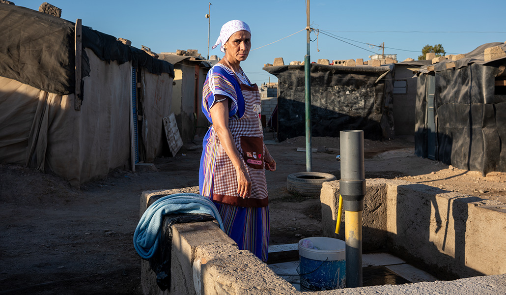 Una mujer migrante en uno de los puntos de suministro de agua de Atochares.