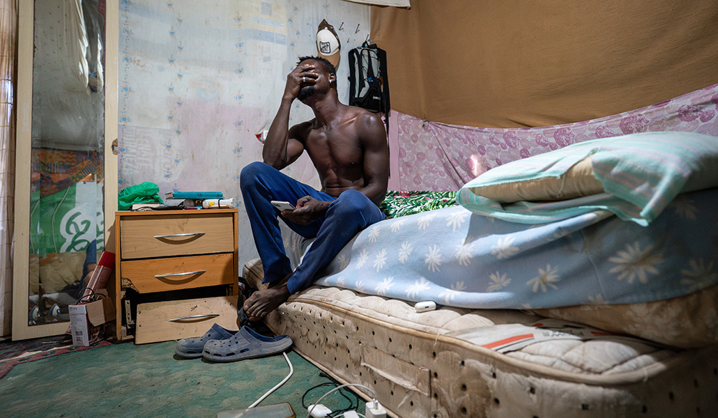 Dos colchones, telas para dar apariencia de hogar y varias mantas forman el dormitorio de Emmanuel.