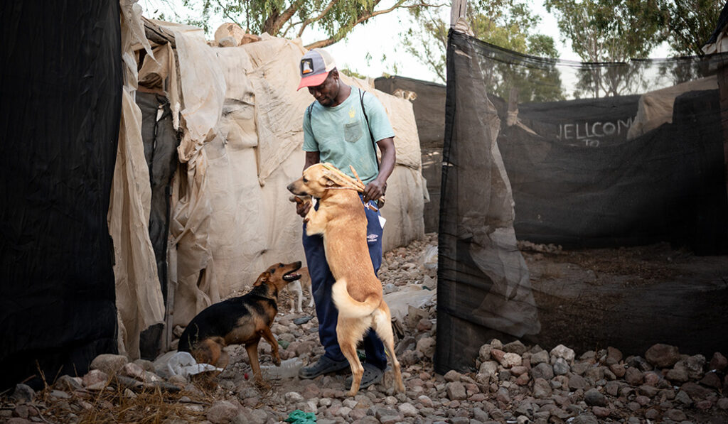 Con su mascota delante de su chabola.