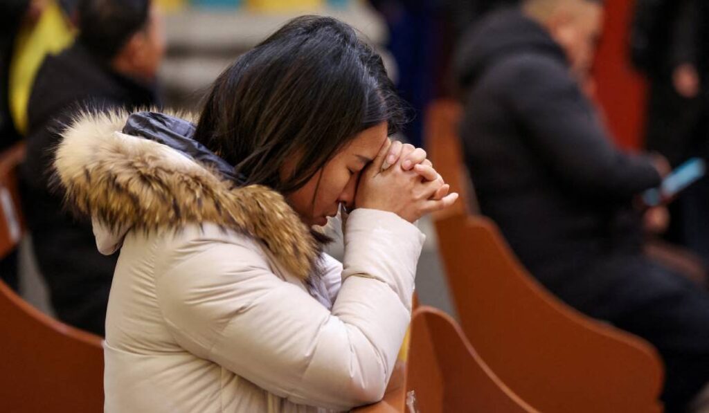 Una mujer ora en una iglesia en China. Foto: CNS.