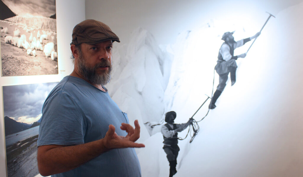 Donoso sobre un mural con una imagen de De Agostini.