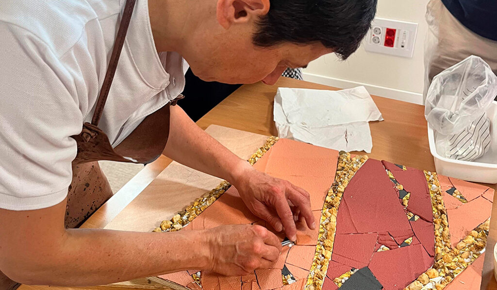 La religiosa monta el cuadro con teselas escritas por detrás por víctimas de abusos.