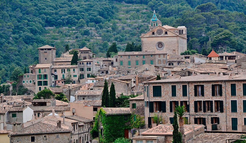 La cartuja está enclavada en la sierra de Tramontana y rodeada de casas de pueblo que atraen a excursionistas.