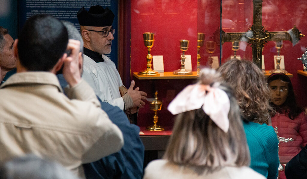 Uno de los actores muestra objetos litúrgicos de la basílica.