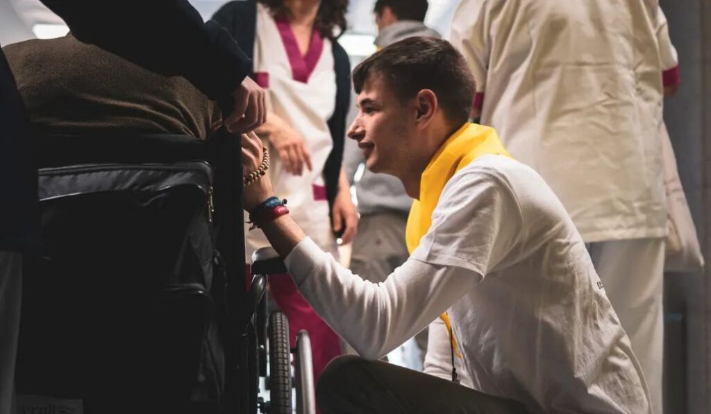 Un joven del Regnum Christi hace misión con una persona con discapacidad.